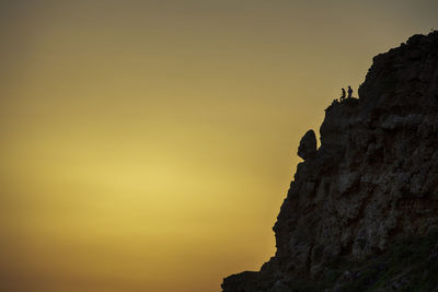 Low angle view of rock formation against sky during sunset