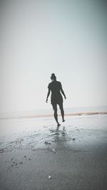 Full length of man on beach against clear sky