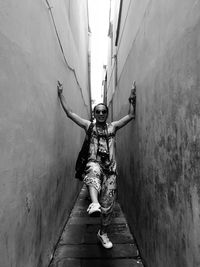 Full length of man standing on alley amidst buildings