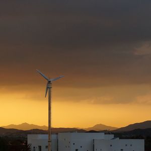 Silhouette of windmill against sky at sunset