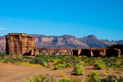 Rock formations on landscape against blue sky