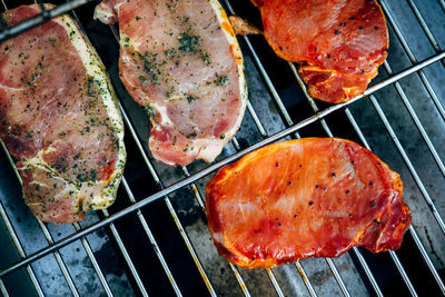 Directly above shot of meat being cooked on barbecue grill