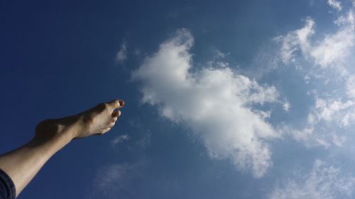 Low angle view of cropped hand against clear sky