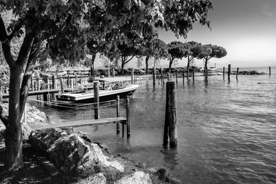 Wooden posts in sea against sky