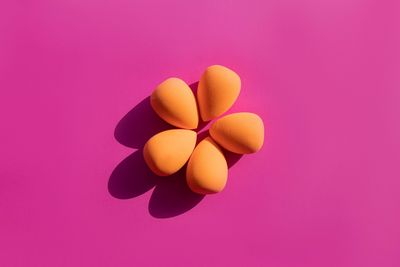 Makeup sponges on a pink background with hard shadows from the sun. high quality photo