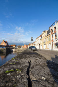 Buildings by houses against blue sky