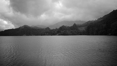 Scenic view of lake by mountains against sky