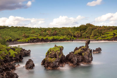 Scenic view of rocks in sea against sky