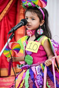 Cute girl wearing costume standing by microphone