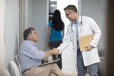 Doctor shaking hands with patient in medical practice