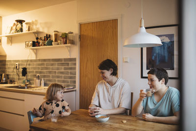 Mothers and daughter sitting in kitchen