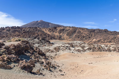 Scenic view of mountains against blue sky