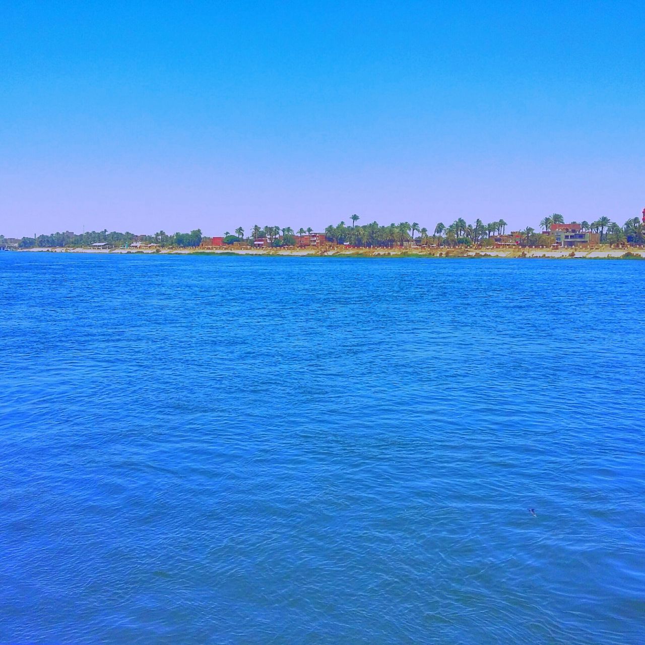 blue, water, clear sky, sea, copy space, waterfront, built structure, building exterior, architecture, tranquil scene, tranquility, rippled, scenics, beauty in nature, nature, city, ocean, outdoors, idyllic, day