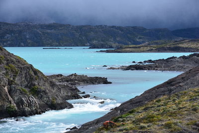 Scenic view of sea and mountains against sky