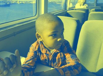 Boy looking away while traveling in boat