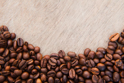 High angle view of roasted coffee beans on wooden table