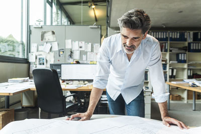 Architect working on ground plan in office