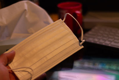 Close-up of hand holding book on table