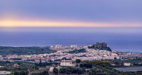 High angle view of townscape by sea against sky