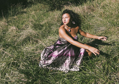 High angle view of contemplating woman sitting on field