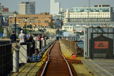 People walking by railway bridge in city