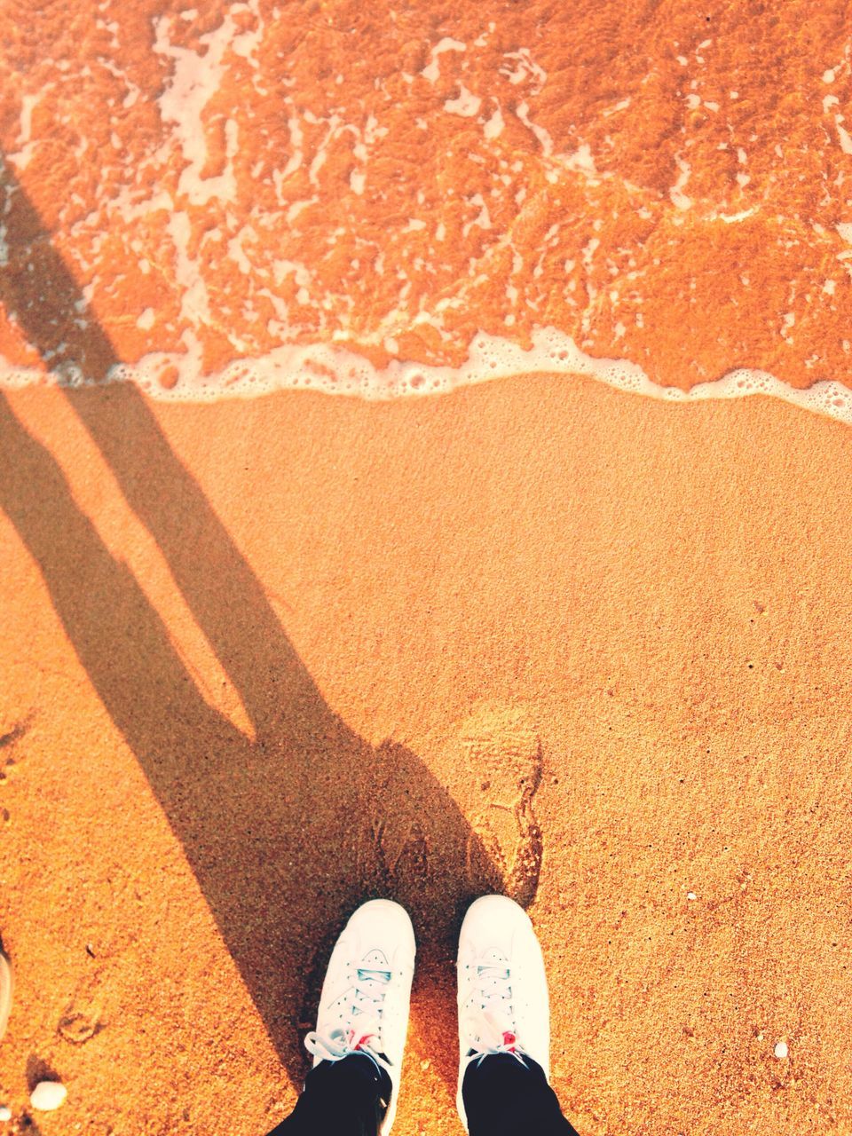 low section, person, personal perspective, human foot, standing, shoe, high angle view, lifestyles, unrecognizable person, men, leisure activity, footwear, beach, sand, shadow, outdoors