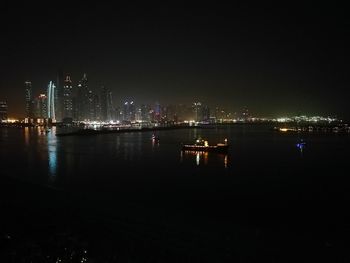 Illuminated bridge over river at night