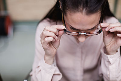 Close-up of businesswoman wearing eyeglasses while sitting at office