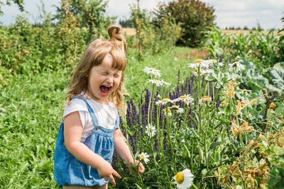 Girl with flowers on field