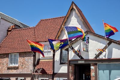 Low angle view of flags on building against sky