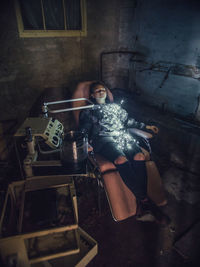 Portrait of young woman sitting on chair at home