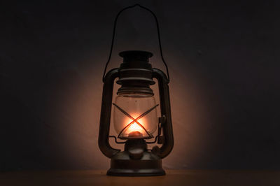 Close-up of illuminated oil lamp on table