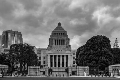 Buildings in city against cloudy sky