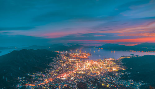 High angle view of illuminated cityscape against sky at night