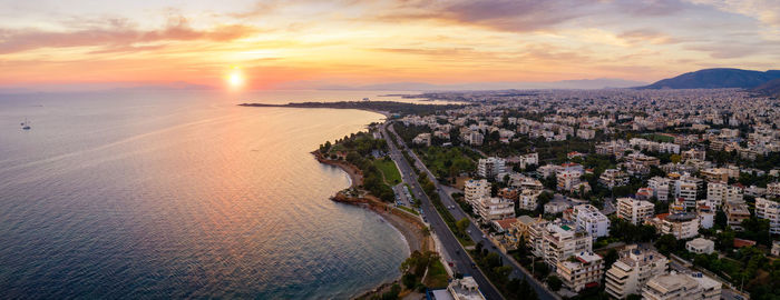 High angle view of cityscape by sea during sunset