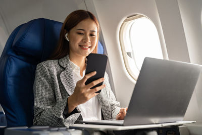 Young businesswoman using laptop while sitting on sofa at home