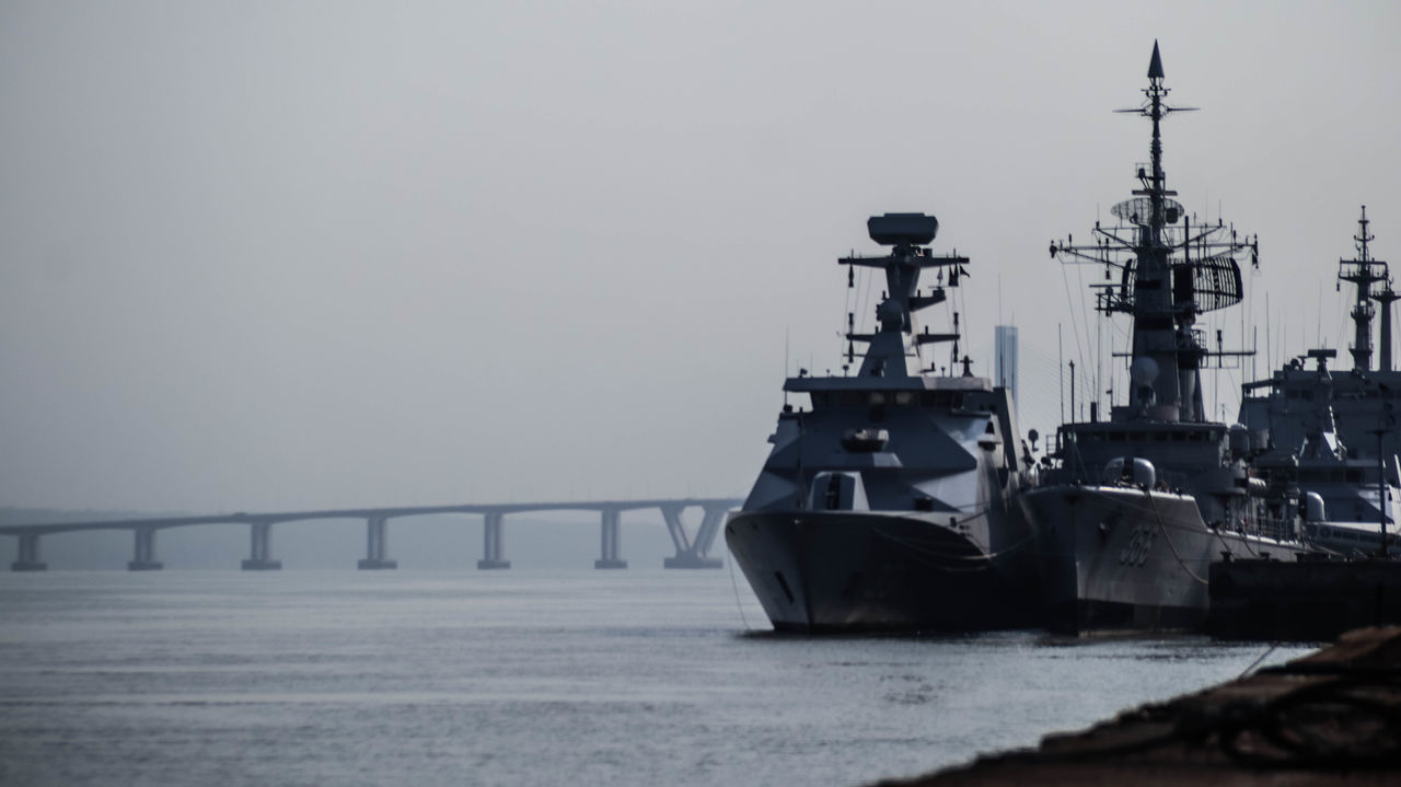 water, transportation, nautical vessel, sea, destroyer, ship, sky, nature, navy, architecture, mode of transportation, vehicle, battleship, guided missile destroyer, watercraft, no people, warship, built structure, naval ship, pier, outdoors, industry, fog, bridge, frigate, environment, copy space, day, travel