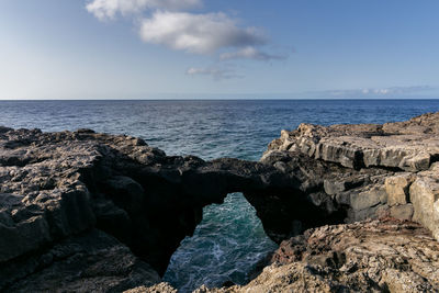 Rocks on sea shore against sky