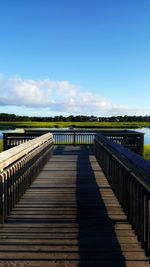 Bridge over calm blue sea against sky