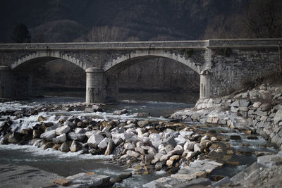 Bridge over river against rocks