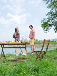 Rear view of couple sitting on field