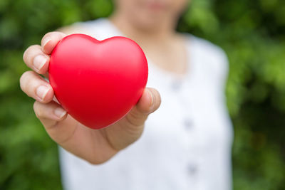 Midsection of woman holding red balloon