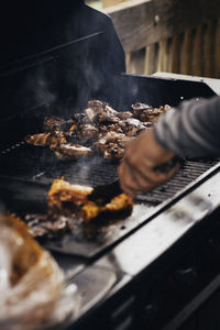 Person preparing food on barbecue grill