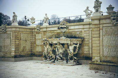 Statue by historic building against sky