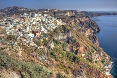 Aerial view of sea by cliff against sky