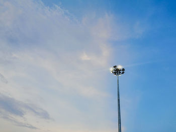 Low angle view of floodlight against blue sky