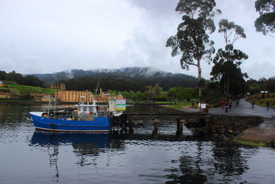 Boats moored in river against sky