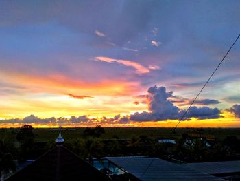 Smoke stacks against sky during sunset