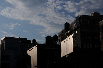 Low angle view of buildings against cloudy sky