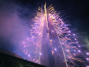 Low angle view of fireworks against sky at night